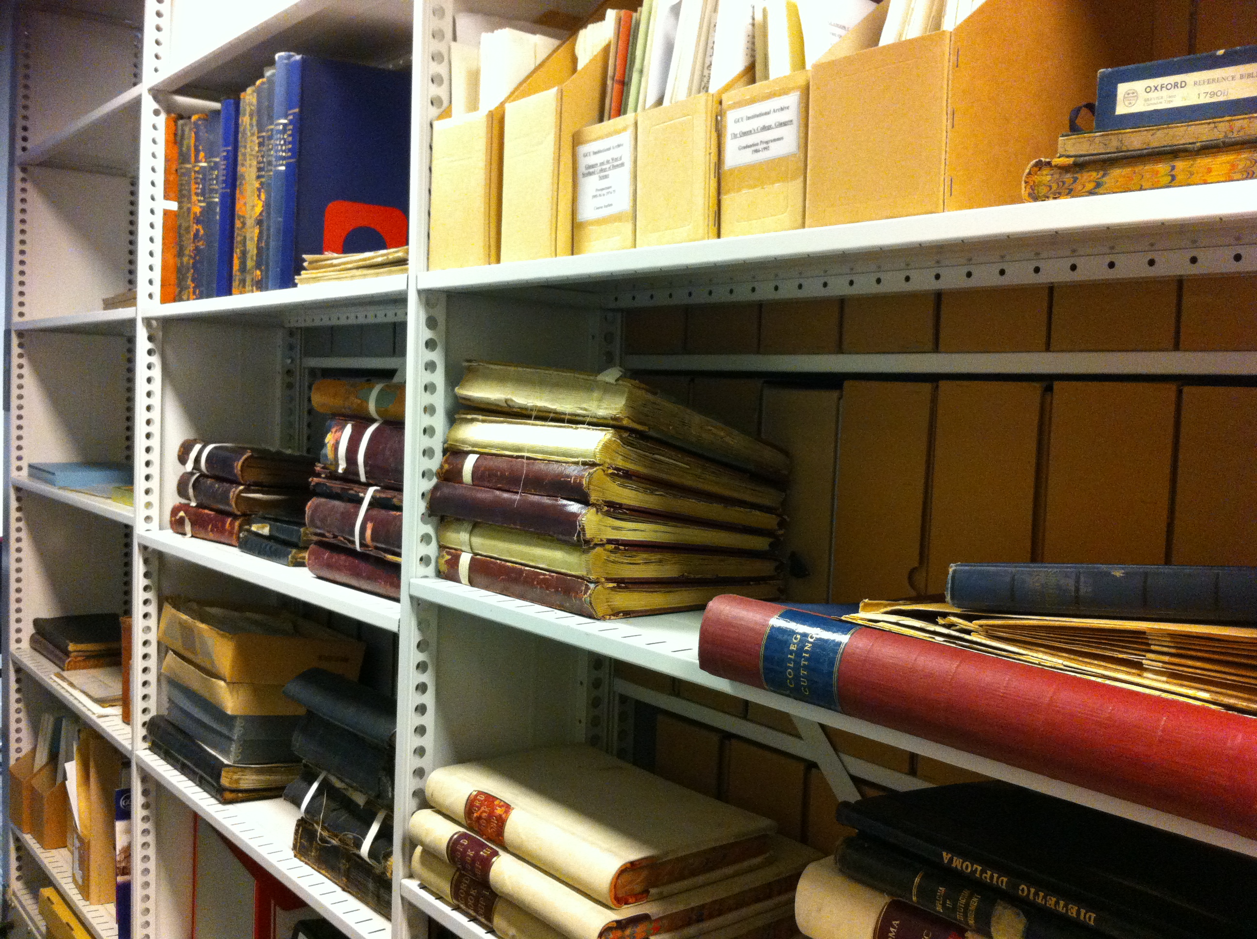 photograph of document boxes and volumes on shelves