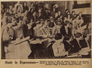 newspaper cutting showing black and white photograph of a lecture theatre full of women
