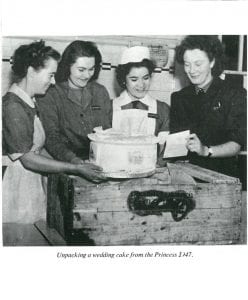 Black and white photograph of students with the tier of a wedding cake