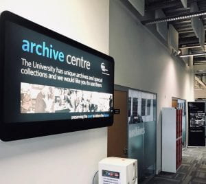 sign for GCU Archive Centre in foreground. Behind can see red lockers