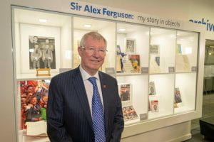 Sir Alex Ferguson standing at display of his objects at Sir Alex Ferguson Library